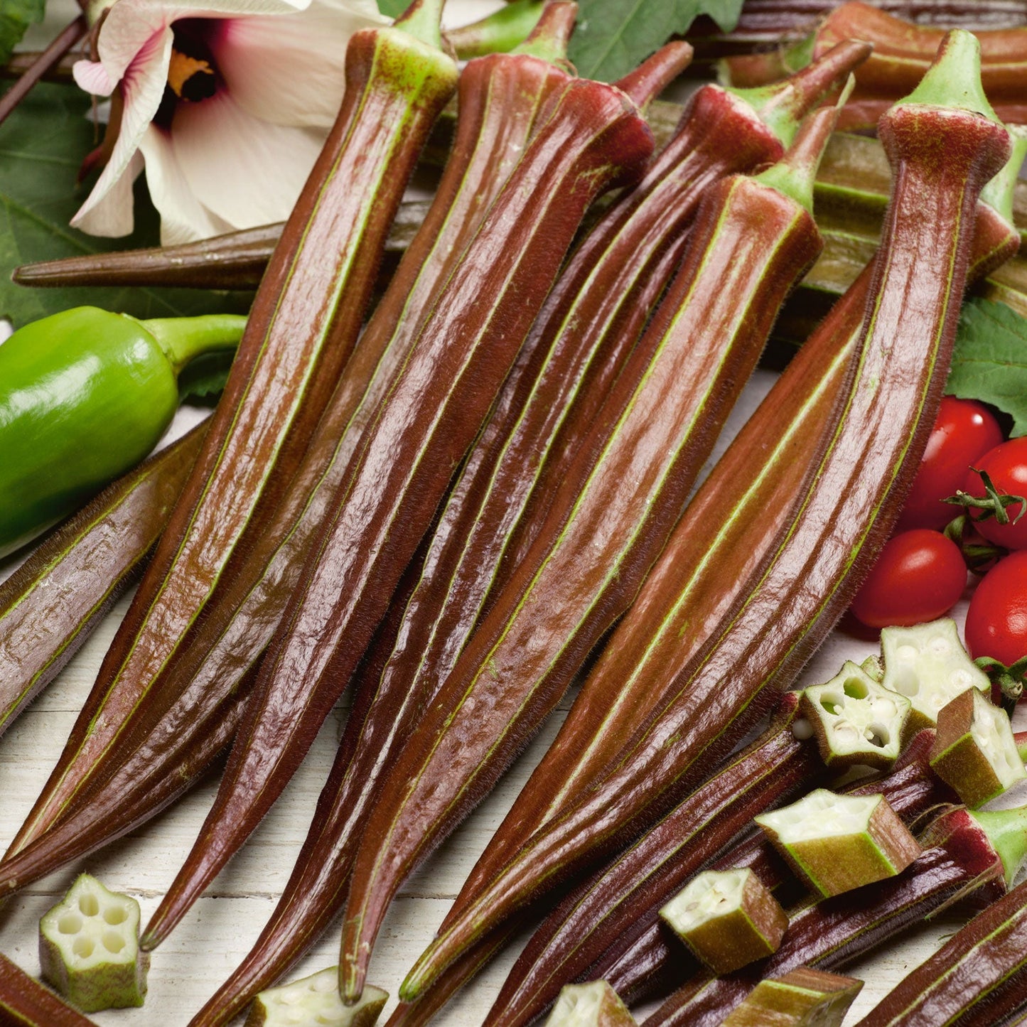 Several elongated Red Burgundy okra showing its deep red skin and green stems.