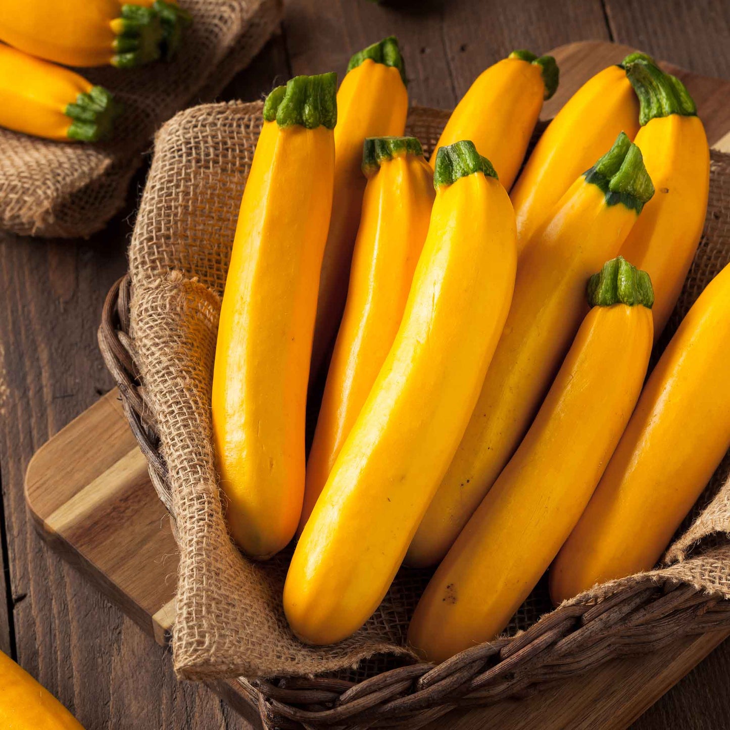 A basket of Golden Zucchini squash showing vibrant skin and green stems.