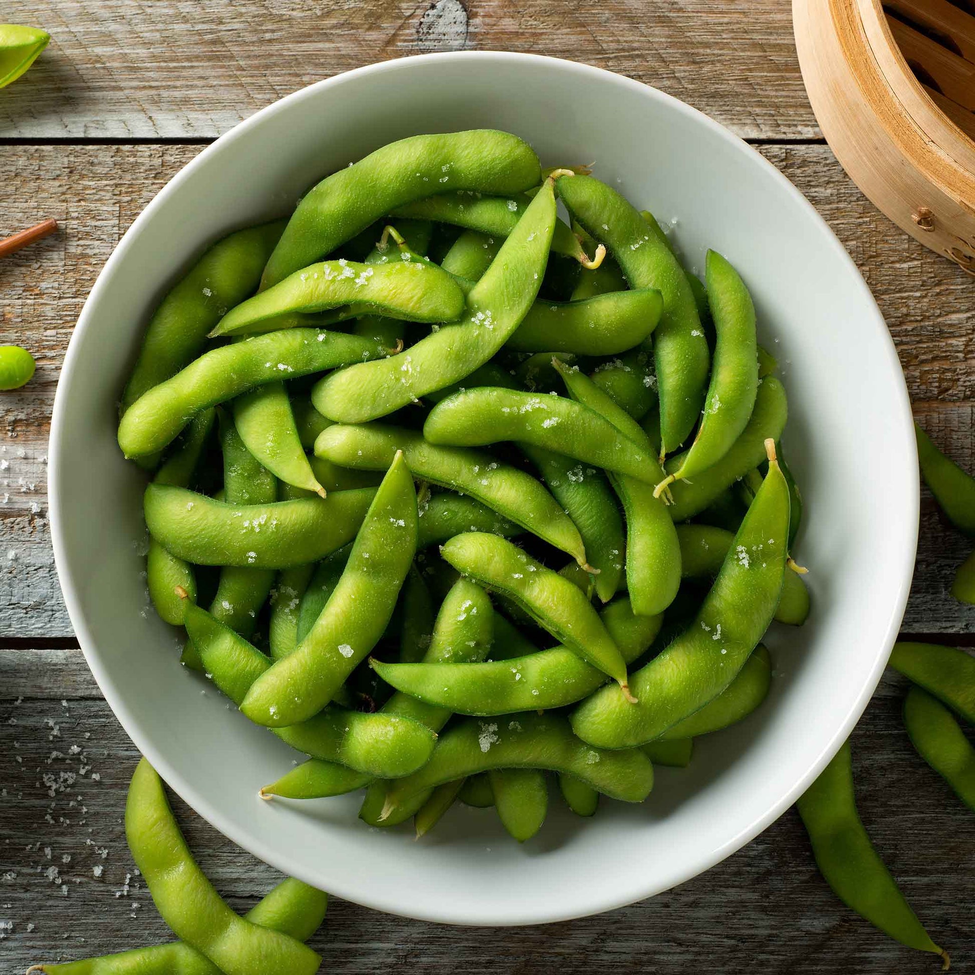 A close-up shot of ready to eat edamame beans in their pods in a bowl.