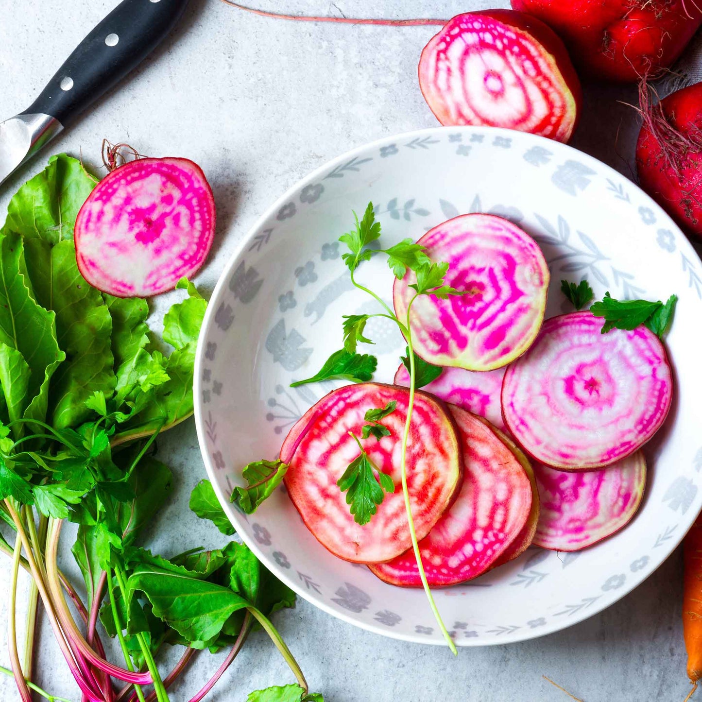 A close-up shot of several raw Chioggia beets with their striped interiors visible.