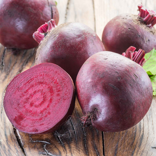 A close-up of several red crosby egyptian beet roots against a light background.