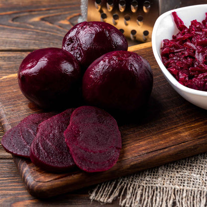A close-up of harvested Detroit Dark Red beets, showcasing their deep red color and smooth skin.