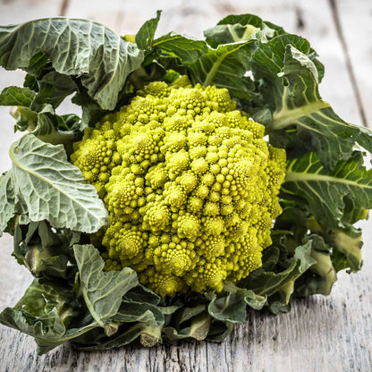 A close-up shot of vibrant green Romanesco broccoli, showcasing its unique fractal patterns and conical florets.