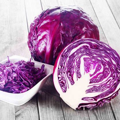 A close-up of vibrant red acre cabbage with tightly packed leaves, showcasing its rich color and texture.