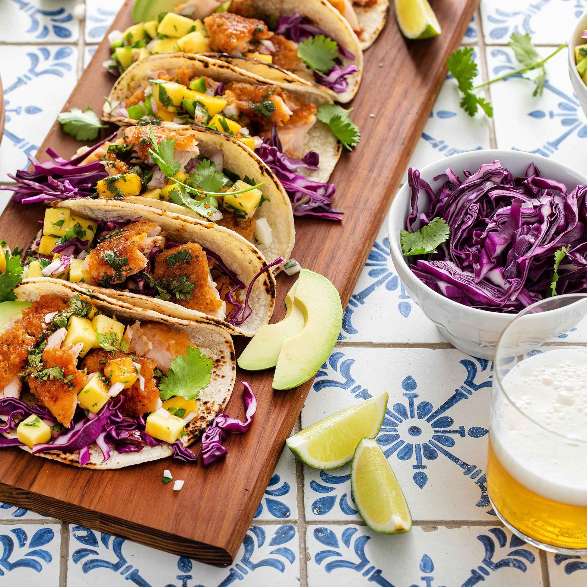 Several tacos garnished with Red Express cabbage on a tiled surface.