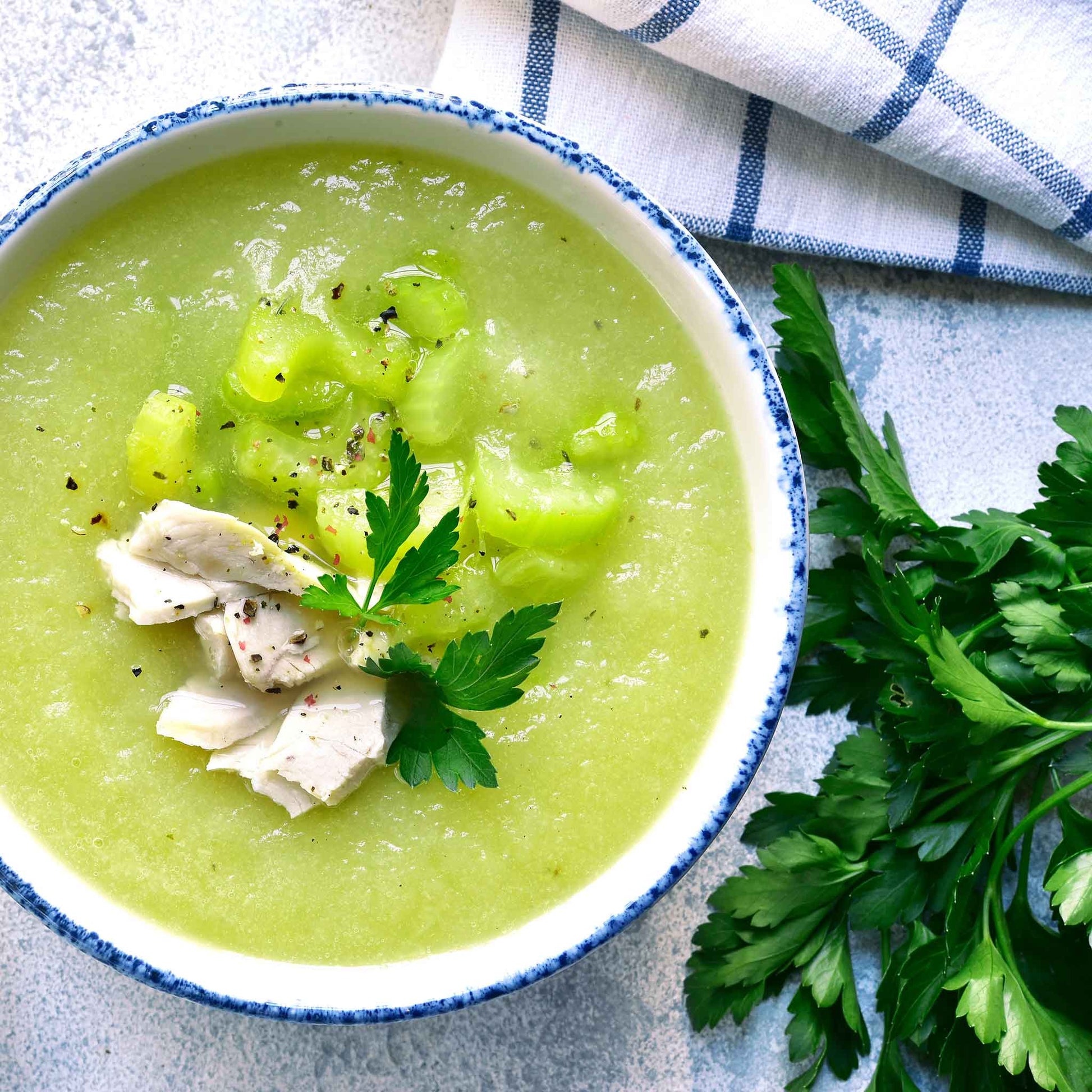 A green soup with Tall Utah celery stalks in the soup.