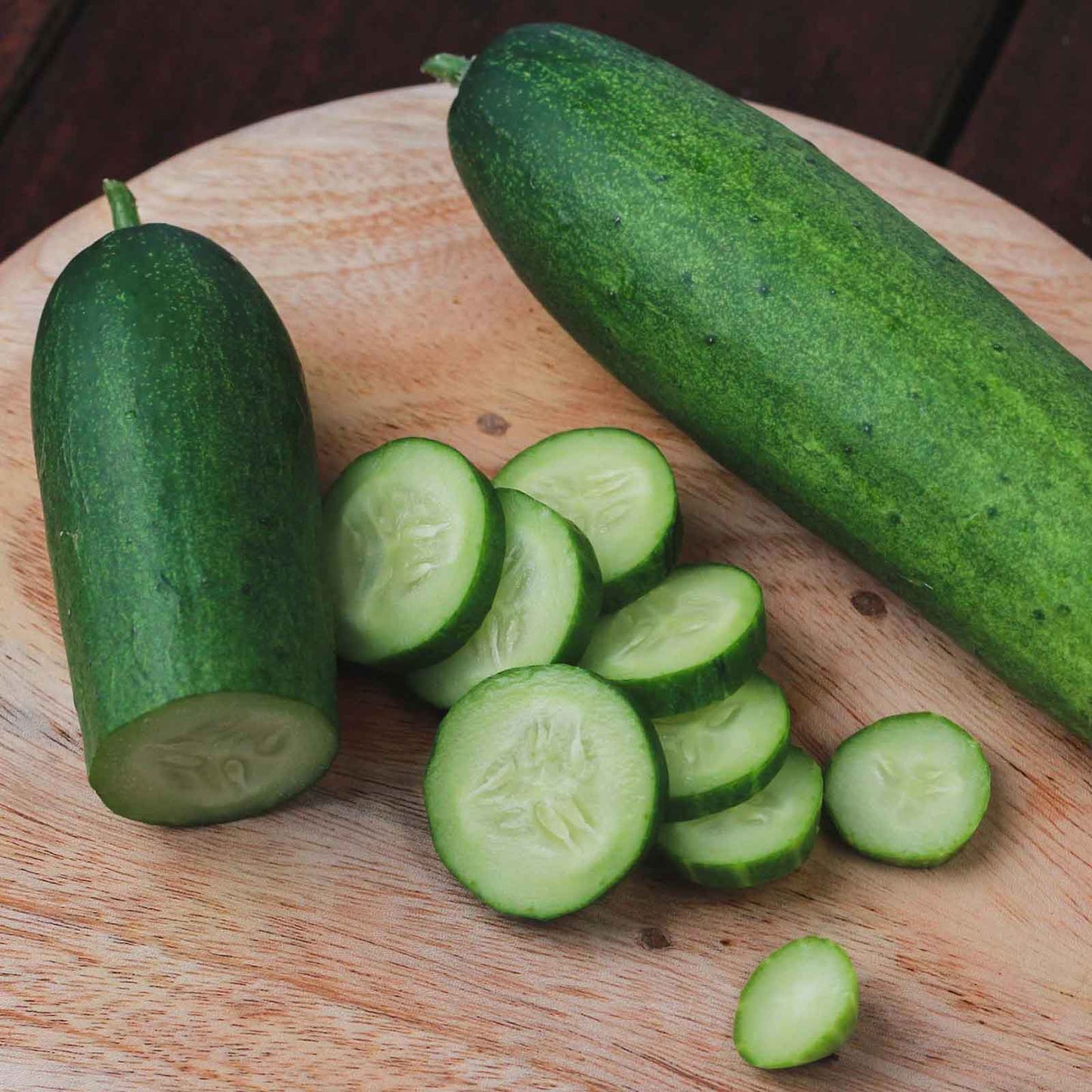 A close-up view of a vibrant green Straight 8 cucumber, showcasing its smooth skin and elongated shape.