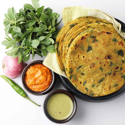 A close-up shot of fresh fenugreek leaves next to several dishes using fenugreek as an ingredient.