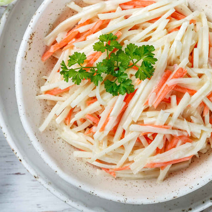 Sliced White Vienna kohlrabi on a plate with a sliced orange vegetable ready to eat.