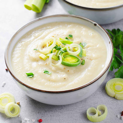 A bowl of potato soup topped with American Flag Leeks for garnish.