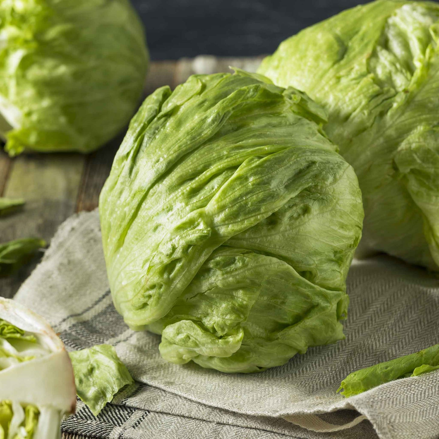 A close-up shot of a vibrant, crisp iceberg lettuce head, showcasing its tightly packed, pale green leaves.