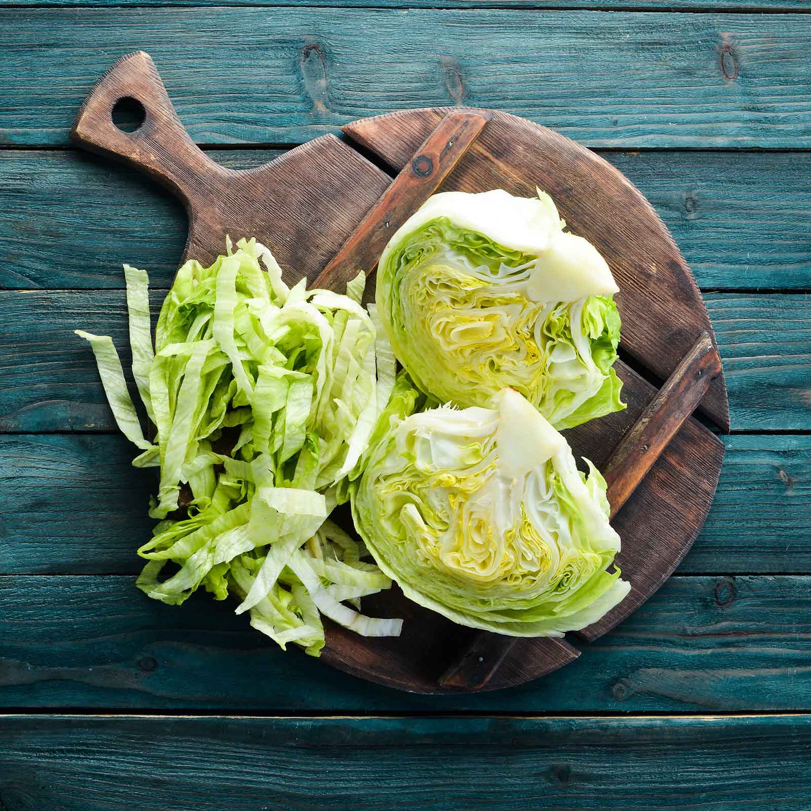 Iceberg lettuce on a cutting board chopped and ready to use.