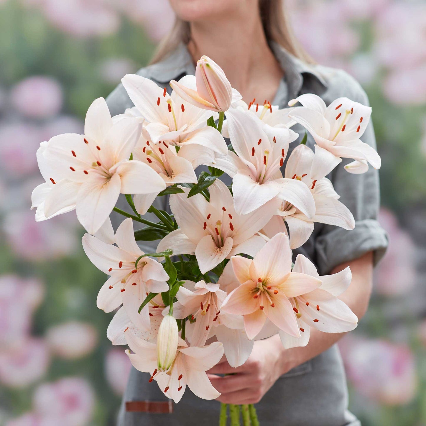Orange lily coral county with darker speckles on petals held in an outdoor setting.