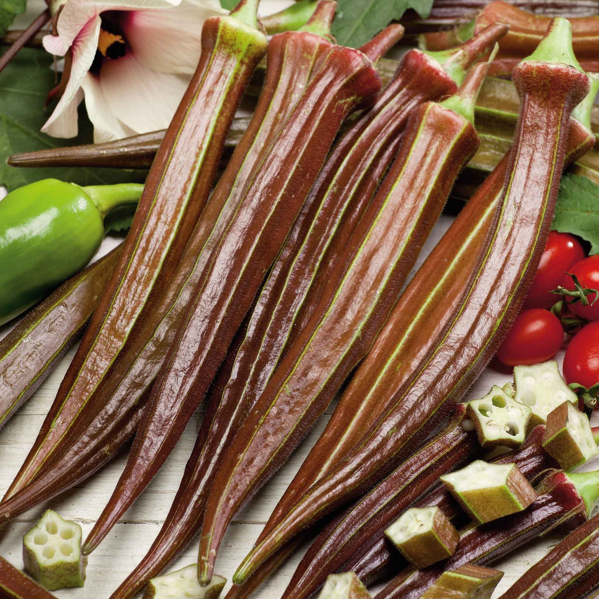 Several elongated Red Burgundy okra showing its deep red skin and green stems.