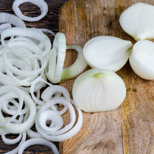 Ringmaster White Sweet Spanish onions shown as whole halves and crisp rings on a cutting board