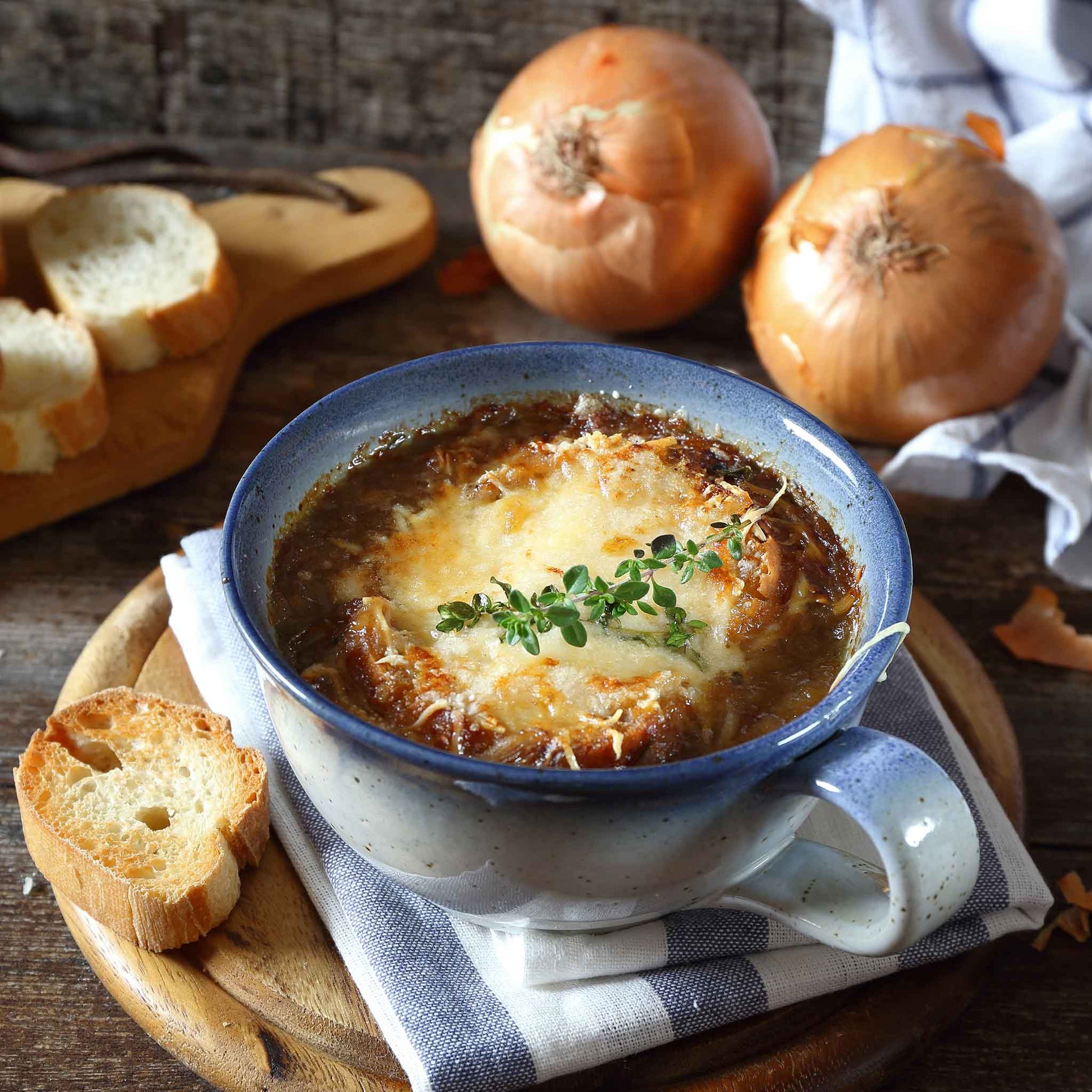 A bowl of soup using Yellow Granex onions with other onions in the background.