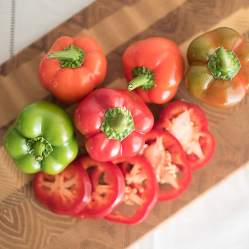 Chili Pie F1 peppers on a cutting board with one pepper sliced in front showing the inside.