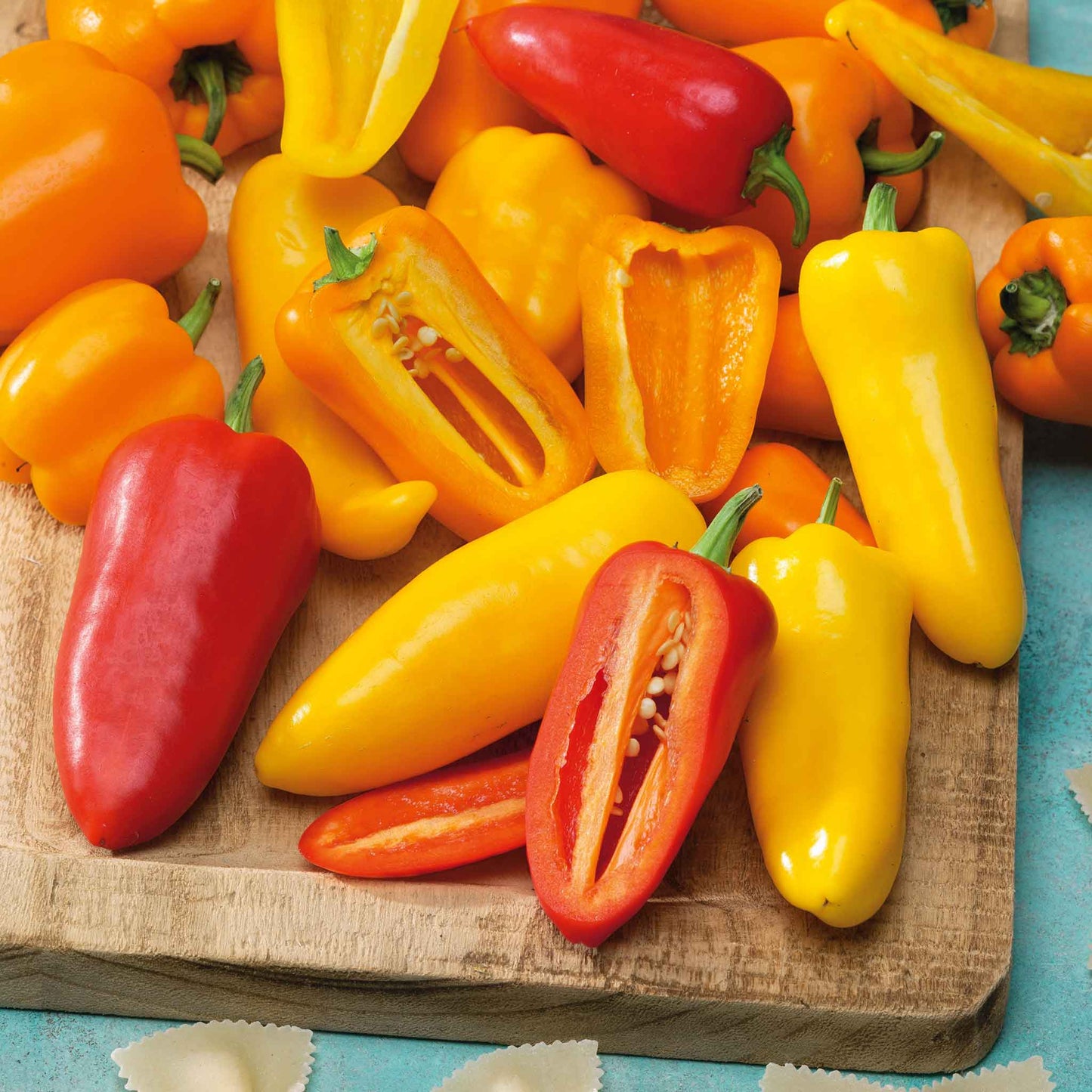 Several Santa Fe Grande red and orange peppers with some cut open.