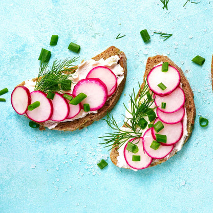 Sliced French Breakfast radishes on pieces of toast to be eaten.