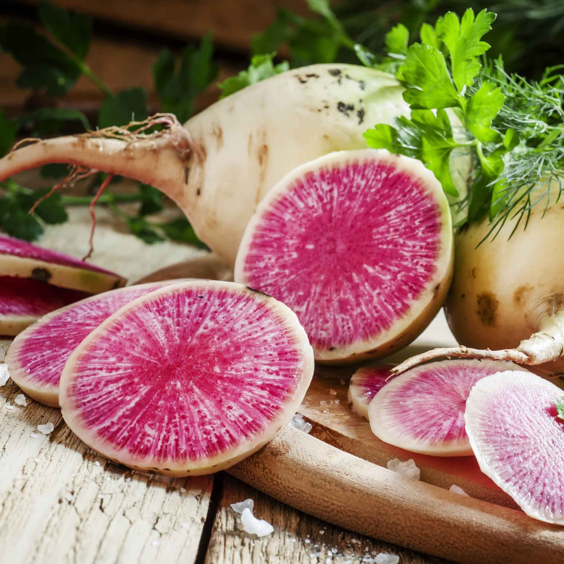 A sliced watermelon radish showing its green skin and bright red interior.