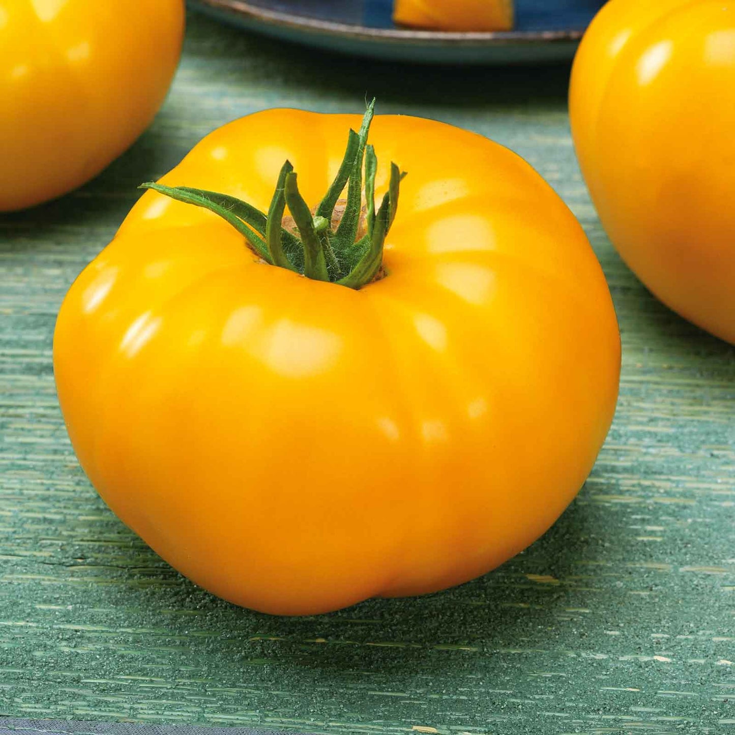 A bright yellow Lemon Boy tomato, with a smooth skin and a slightly irregular shape.